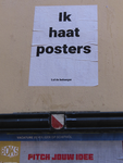 902280 Afbeelding van een poster met de tekst 'Ik haat posters', geplakt boven een gemeentelijk reclamebord in de ...
